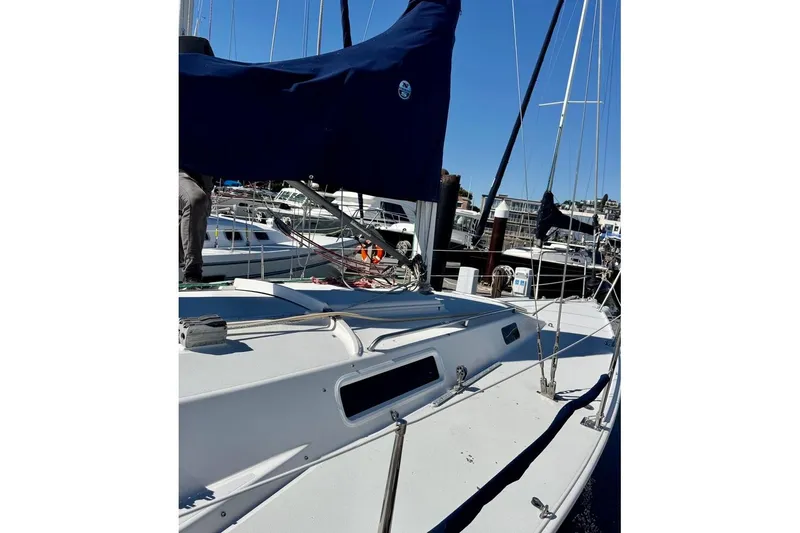 Slide: The Image of 1999 J Boats J/105 sailboat docked at marina, featuring sleek white deck and blue sail cover. - 2