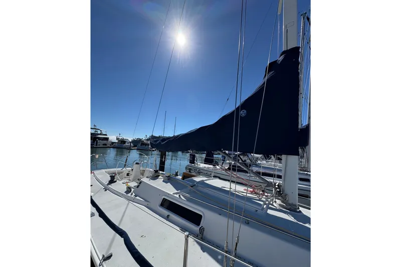 Slide: The Image of Sailboat J/105 from 1999 docked under a clear blue sky. - 3
