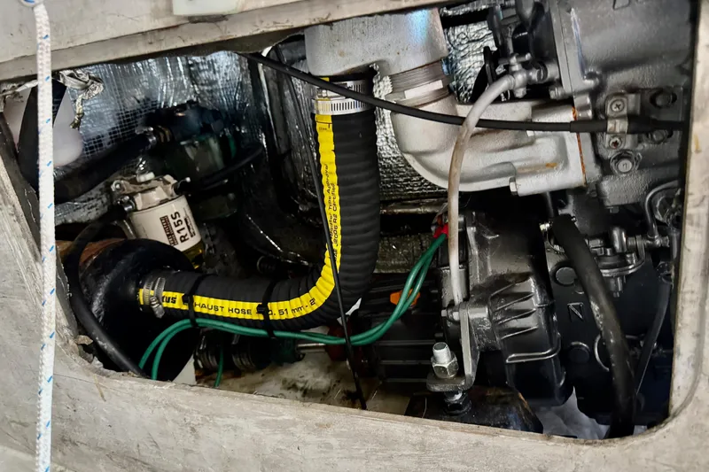 Slide: The Image of Engine compartment of a 1999 J Boats J/105 sailboat, showing mechanical components and hoses. - 30