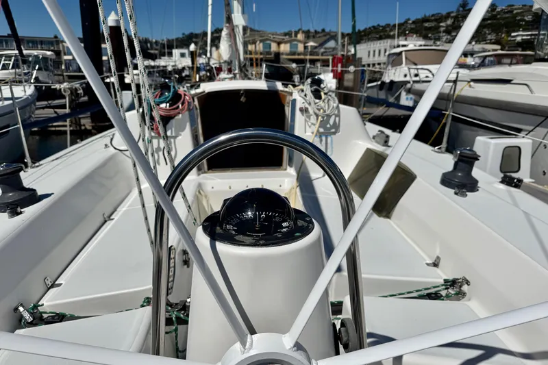Slide: The Image of 1999 J Boats J/105 sailboat cockpit with steering wheel and compass in marina. - 42