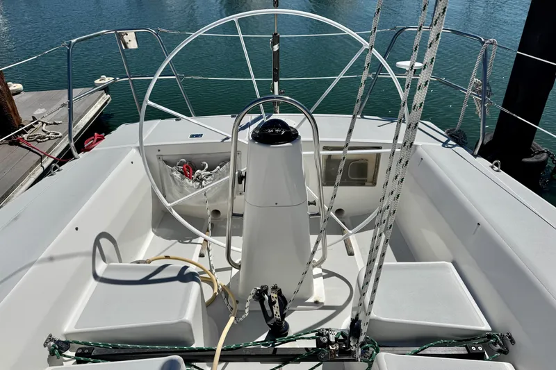 Slide: The Image of 1999 J Boats J/105 sailboat cockpit with steering wheel and ropes, docked at marina. - 44