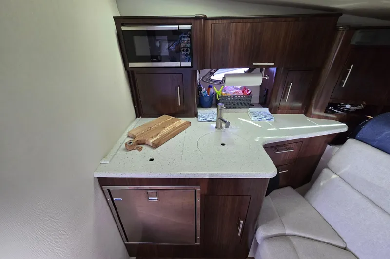 Slide: The Image of 2018 Regal 35 Sport Coupe interior kitchen with modern appliances and wooden cabinetry. - 17