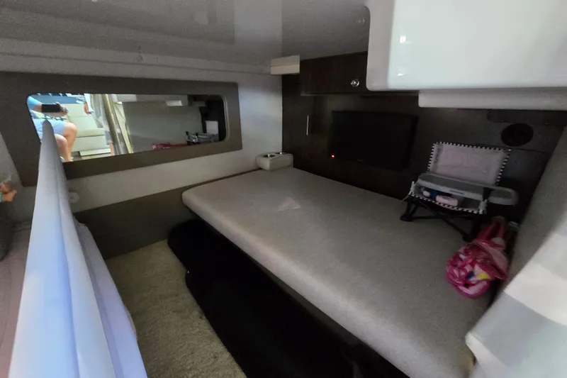 Slide: The Image of 2018 Regal 35 Sport Coupe interior cabin with bed, TV, and storage. - 18