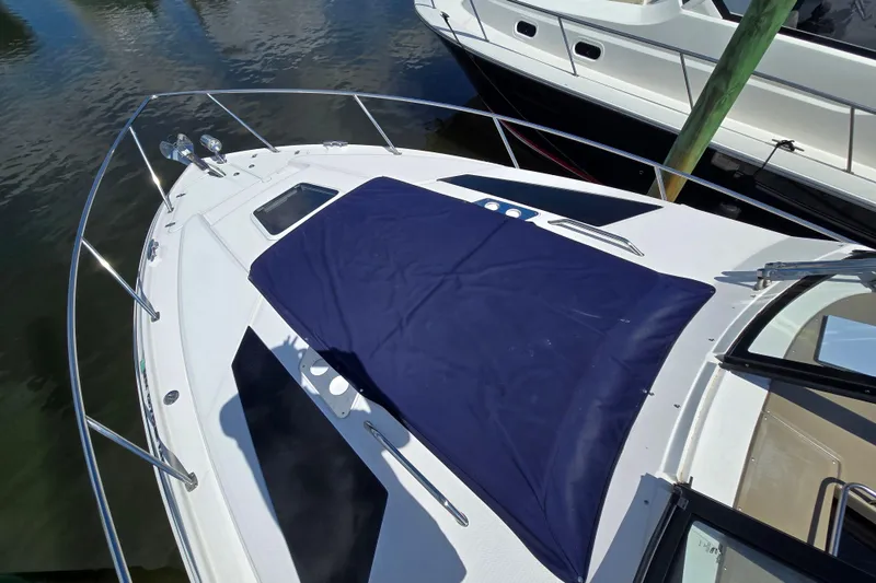 Slide: The Image of 2018 Regal 35 Sport Coupe boat with blue cover, docked at marina. - 23