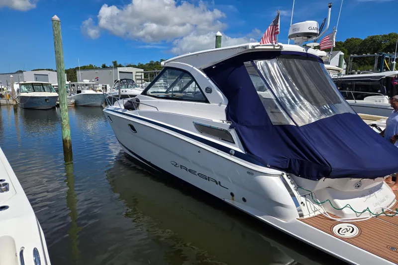 Slide: The Image of 2018 Regal 35 Sport Coupe docked at marina under blue sky. - 24