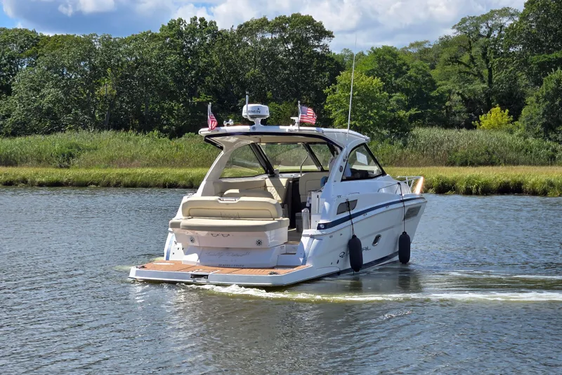 Slide: The Image of 2018 Regal 35 Sport Coupe cruising on a scenic river with lush greenery. - 7