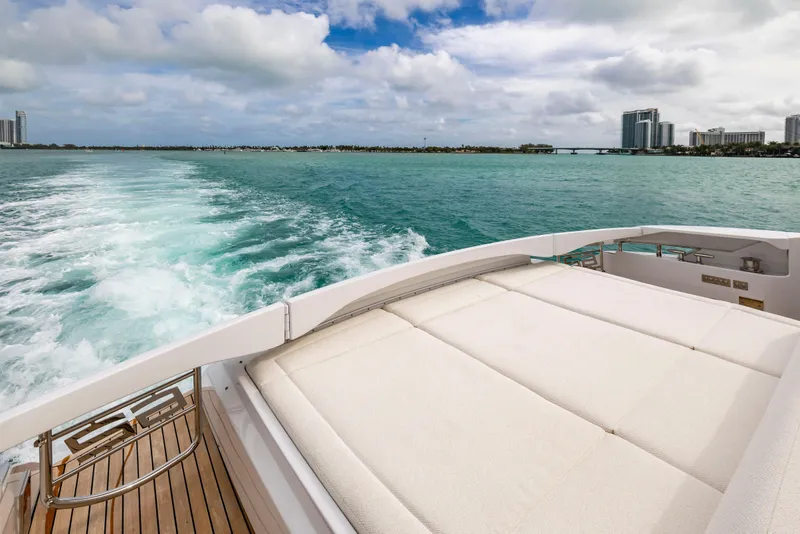 Slide: The Image of 2021 Pershing 62 yacht cruising on turquoise waters with city skyline in background. - 18