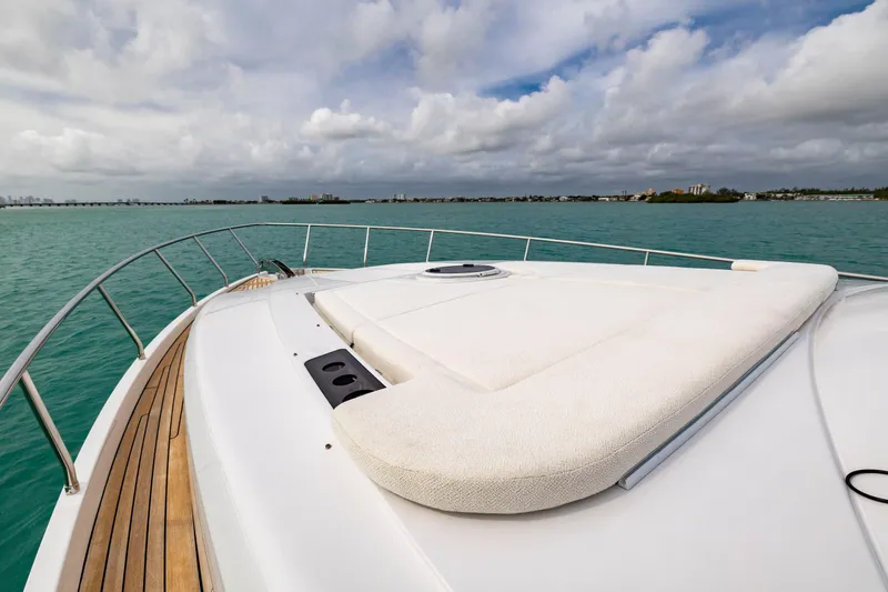 Slide: The Image of Luxury Pershing 62 yacht deck, 2021 model, cruising on turquoise waters under cloudy skies. - 24