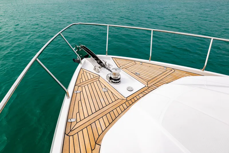 Slide: The Image of Bow of 2021 Pershing 62 yacht with teak deck on turquoise water. - 25