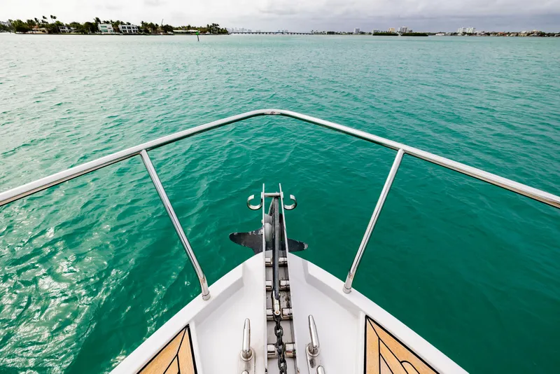 Slide: The Image of Bow view of 2021 Pershing 62 yacht on turquoise water. - 26