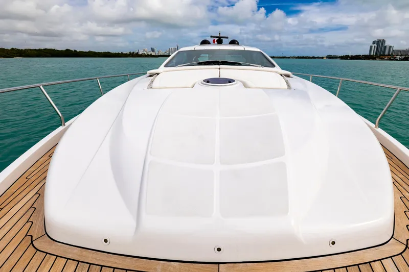 Slide: The Image of Luxury Pershing 62 yacht deck, 2021 model, cruising on turquoise waters under a partly cloudy sky. - 27