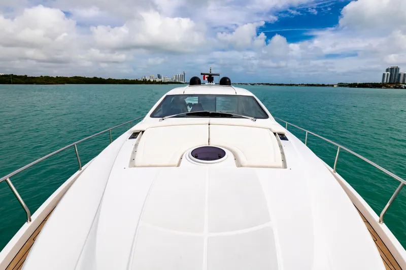 Slide: The Image of 2021 Pershing 62 yacht cruising on turquoise waters under a partly cloudy sky. - 28