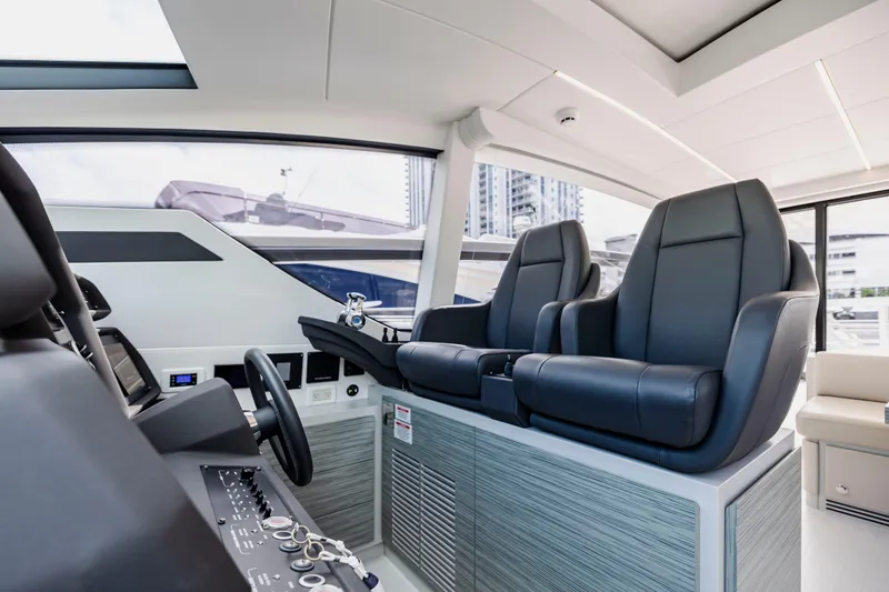Slide: The Image of Luxurious interior of 2021 Pershing 62 yacht with sleek black seating and modern controls. - 48