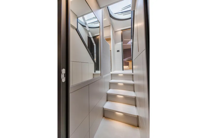 Slide: The Image of Modern interior staircase of 2021 Pershing 62 yacht with sleek design and ambient lighting. - 62