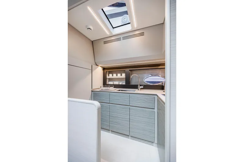 Slide: The Image of Modern kitchen interior of 2021 Pershing 62 yacht with sleek cabinetry and skylight. - 63