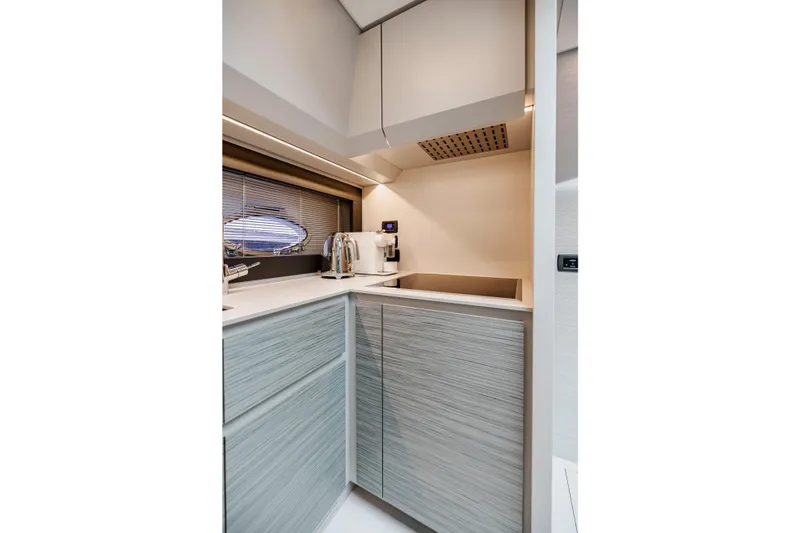 Slide: The Image of Modern kitchen interior on 2021 Pershing 62 yacht, featuring sleek cabinetry and appliances. - 66
