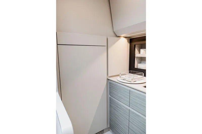 Slide: The Image of Modern kitchen interior of 2021 Pershing 62 yacht, featuring sleek cabinetry and lighting. - 70