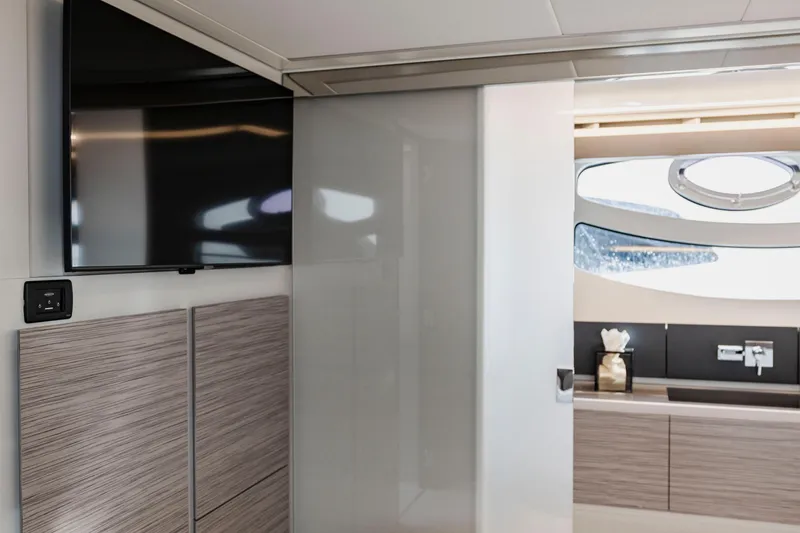 Slide: The Image of Interior of 2021 Pershing 62 yacht featuring modern design with TV and sleek cabinetry. - 76