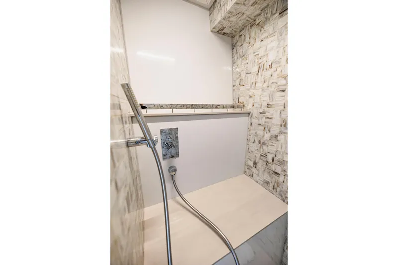Slide: The Image of Luxurious shower area in 2021 Pershing 62 yacht with modern fixtures and elegant tile design. - 83
