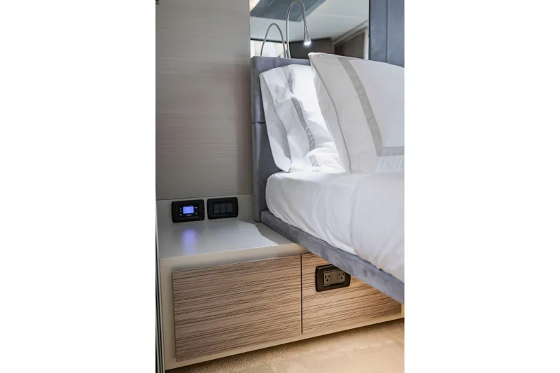Slide: The Image of Luxurious bedroom interior of 2021 Pershing 62 yacht with modern bedside controls. - 88