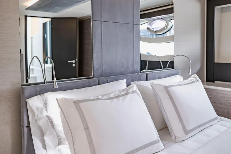 Slide: The Image of Luxurious bedroom interior on a 2021 Pershing 62 yacht, featuring elegant bedding and modern design. - 89