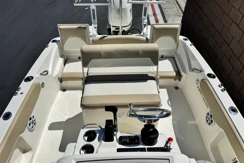 Slide: The Image of 2019 Stingray 206 CC boat interior with beige seating and steering wheel. - 15