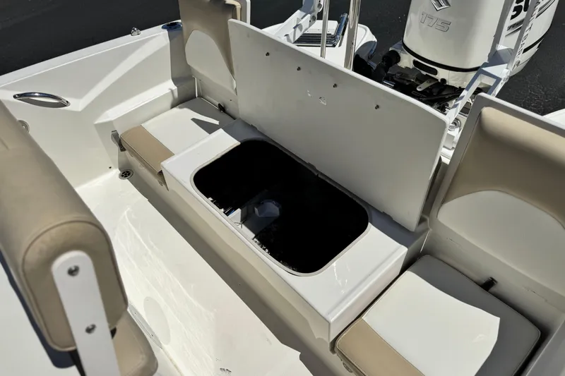 Slide: The Image of 2019 Stingray 206 CC boat interior with open storage compartment and seating. - 18