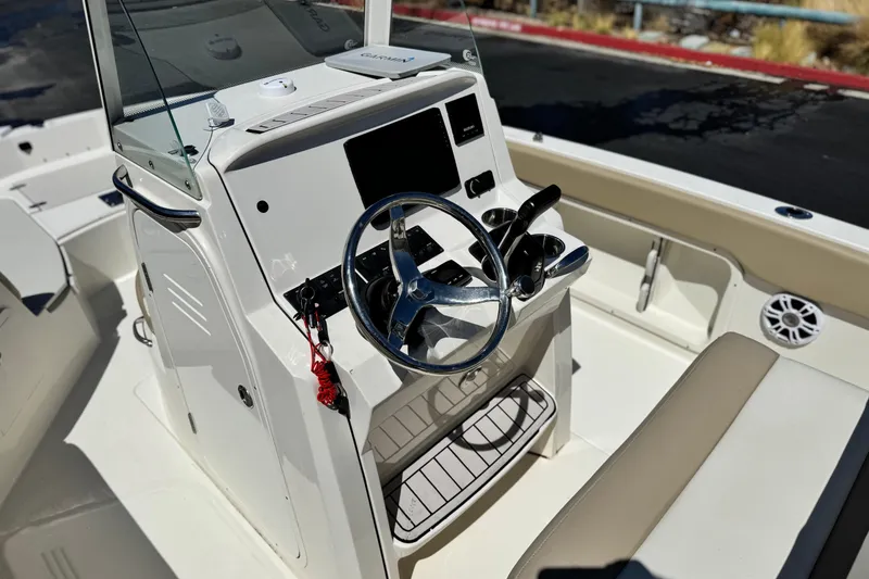 Slide: The Image of 2019 Stingray 206 CC boat interior with steering wheel and control panel. - 24