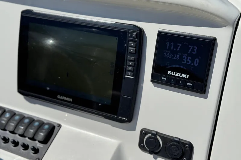 Slide: The Image of Dashboard of a 2019 Stingray 206 CC boat with Garmin and Suzuki displays. - 26