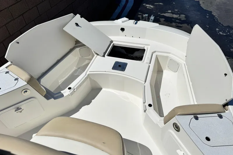 Slide: The Image of 2019 Stingray 206 CC boat interior with open storage compartments and seating. - 8