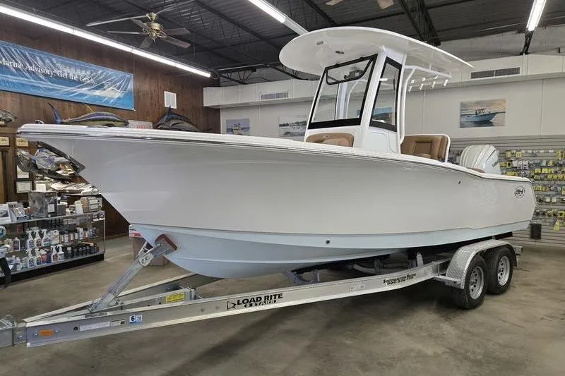 The Image of 2026 Sea Hunt Ultra 245 SE boat on trailer in showroom. - 0