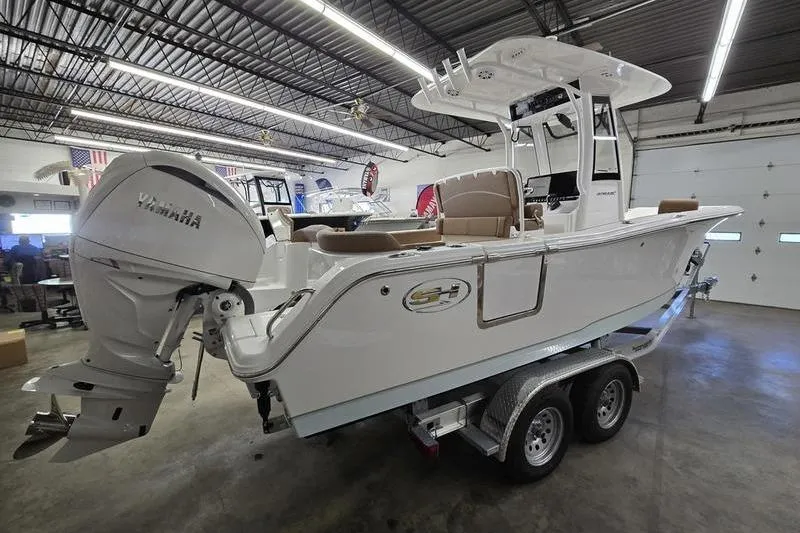 Slide: The Image of 2026 Sea Hunt Ultra 245 SE boat on trailer in showroom, featuring Yamaha outboard motor. - 19