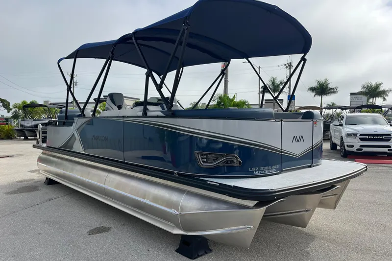 Slide: The Image of 2026 Avalon 2385 LSZ Quad Lounger Tri Toon boat with canopy, parked outdoors. - 3
