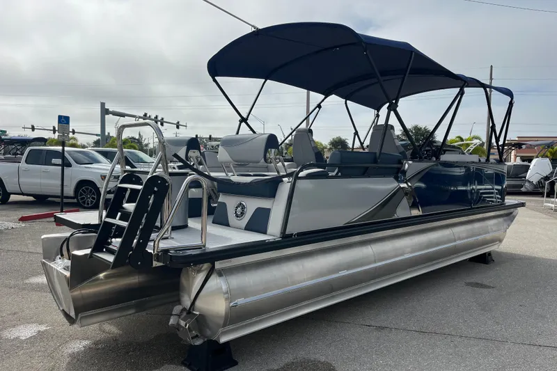 Slide: The Image of 2026 Avalon 2385 LSZ Quad Lounger Tri Toon boat with canopy, parked outdoors. - 5