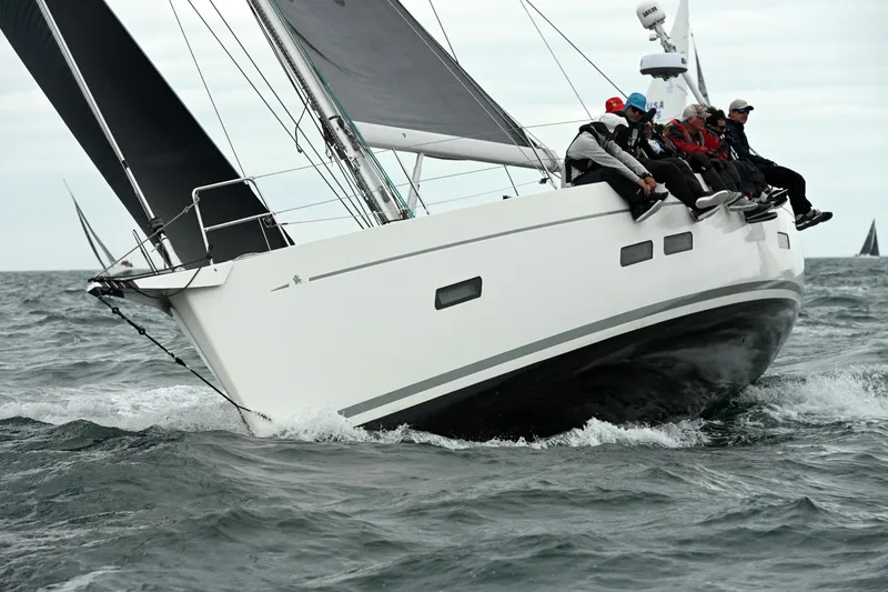 Slide: The Image of Italia Yachts 13.98 sailing with crew, 2015 model, cutting through ocean waves. - 1