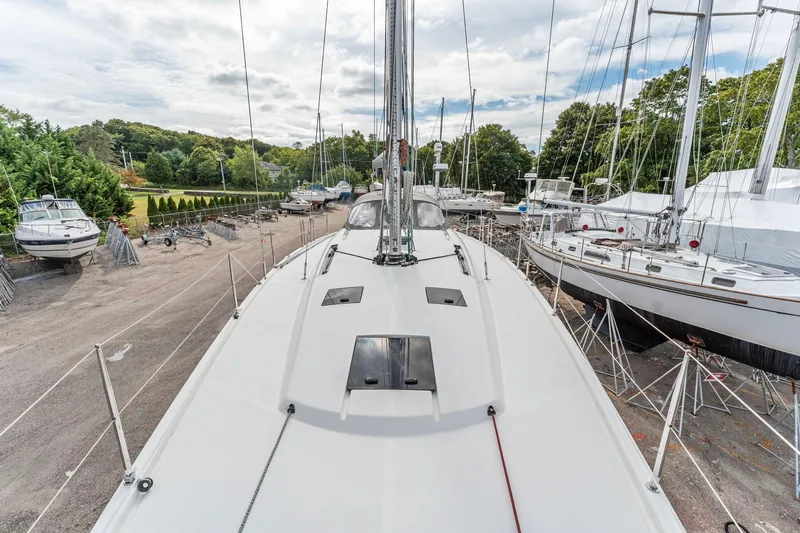 Slide: The Image of Italia Yachts 13.98 (2015) sailboat on land, surrounded by other boats and greenery. - 11