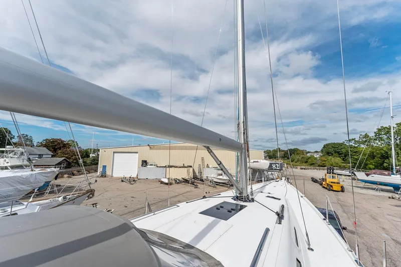 Slide: The Image of Italia Yachts 13.98 sailboat, 2015 model, docked in a shipyard under a partly cloudy sky. - 14