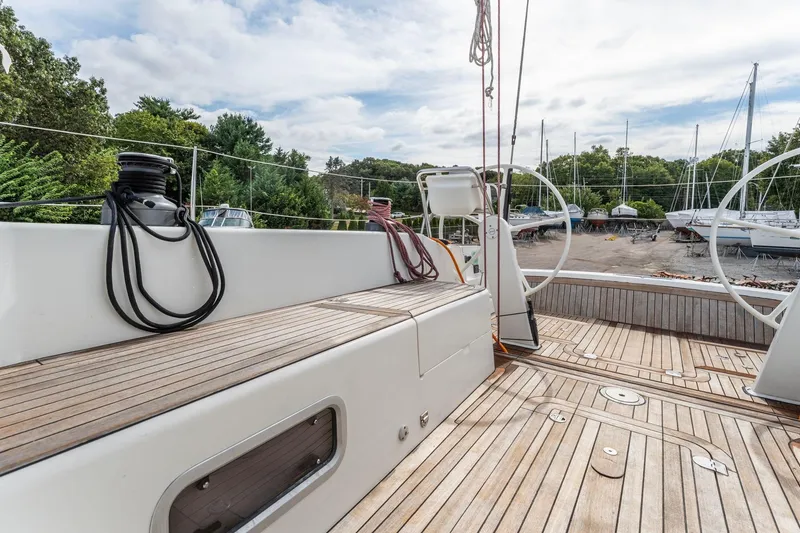 Slide: The Image of Italia Yachts 13.98 (2015) sailboat deck with wooden flooring and dual steering wheels. - 21
