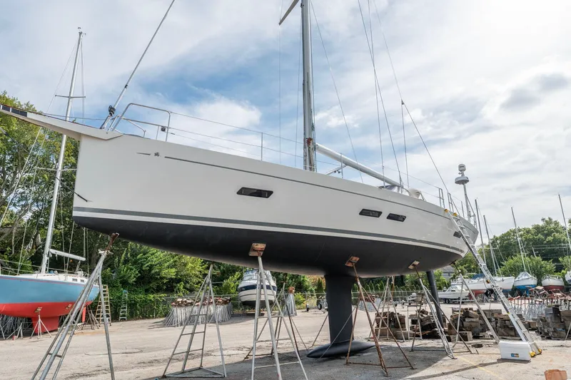 Slide: The Image of Italia Yachts 13.98 sailboat from 2015 on dry dock, surrounded by other boats. - 5