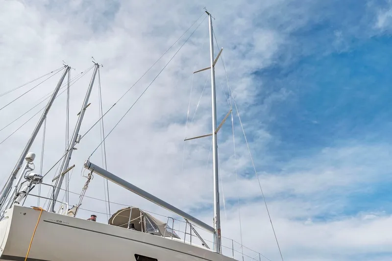 Slide: The Image of Italia Yachts 13.98 sailboat, 2015 model, with tall masts against a cloudy sky. - 8