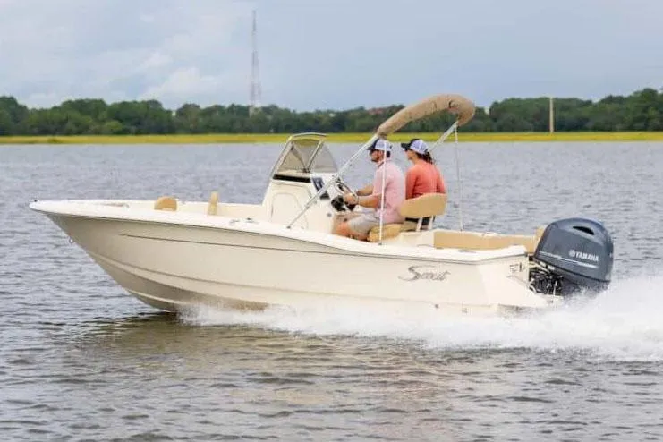 Slide: The Image of Manufacturer Provided Image: 2025 Scout 195 Sportfish boat cruising on a lake with two passengers. - 2