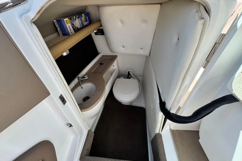 Slide: The Image of 2008 Cobalt 262 boat interior with compact bathroom, sink, and storage shelf. - 24