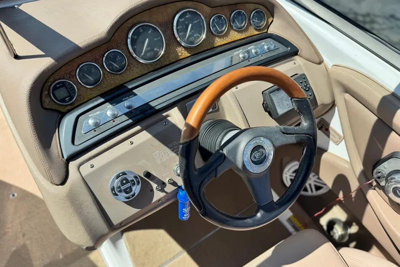 Slide: The Image of Dashboard of a 2008 Cobalt 262 boat with gauges and a wooden steering wheel. - 27