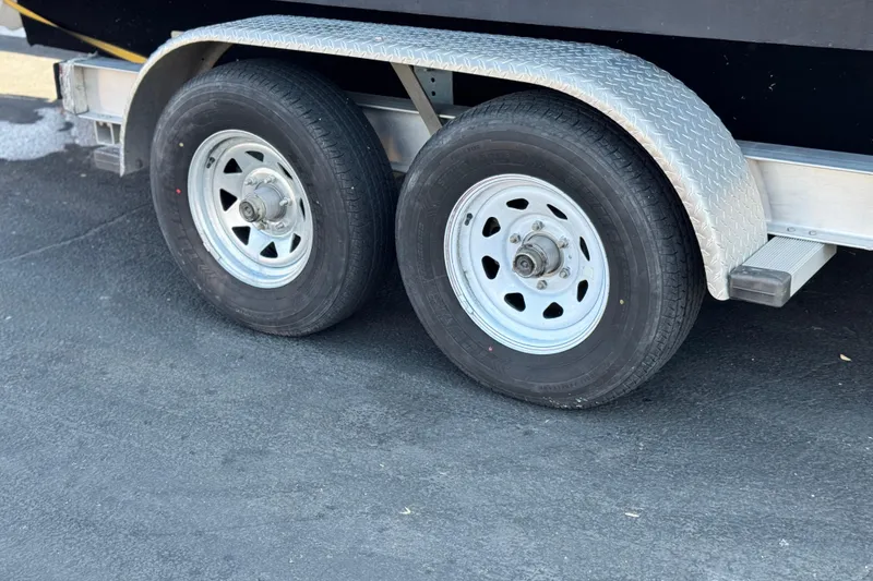 Slide: The Image of Trailer wheels of a 2008 Cobalt 262 boat on asphalt surface. - 28
