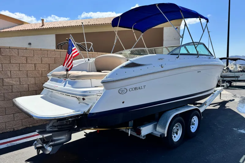 Slide: The Image of 2008 Cobalt 262 boat on trailer with American flag and blue canopy. - 5