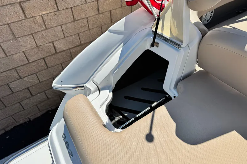 Slide: The Image of 2008 Cobalt 262 boat interior with open storage compartment and beige seating. - 9