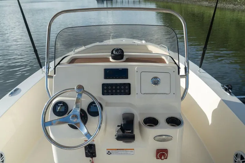 Slide: The Image of Manufacturer Provided Image: 2026 Scout 188 Sportfish boat dashboard with steering wheel and controls on calm water. - 5