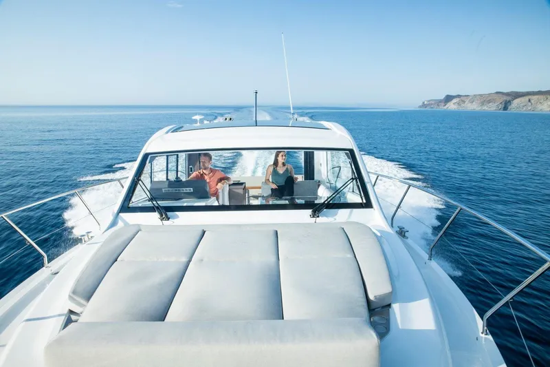 Slide: The Image of 2026 Sealine C390 yacht cruising on open sea with two people onboard. - 13