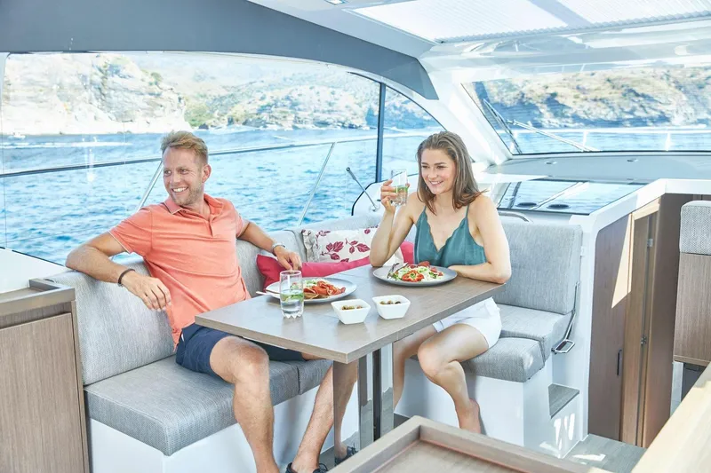 Slide: The Image of Couple dining on a 2026 Sealine C390 yacht, enjoying a scenic ocean view. - 19