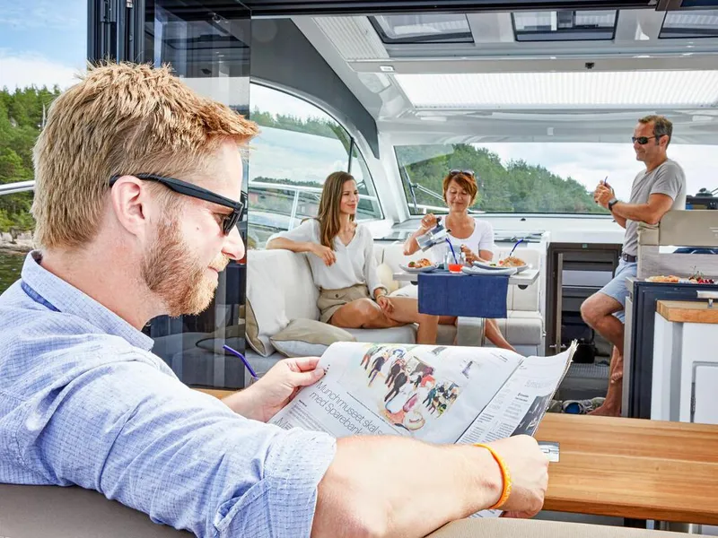 Slide: The Image of People relaxing on a 2026 Sealine C390 yacht, enjoying leisure time and reading. - 24
